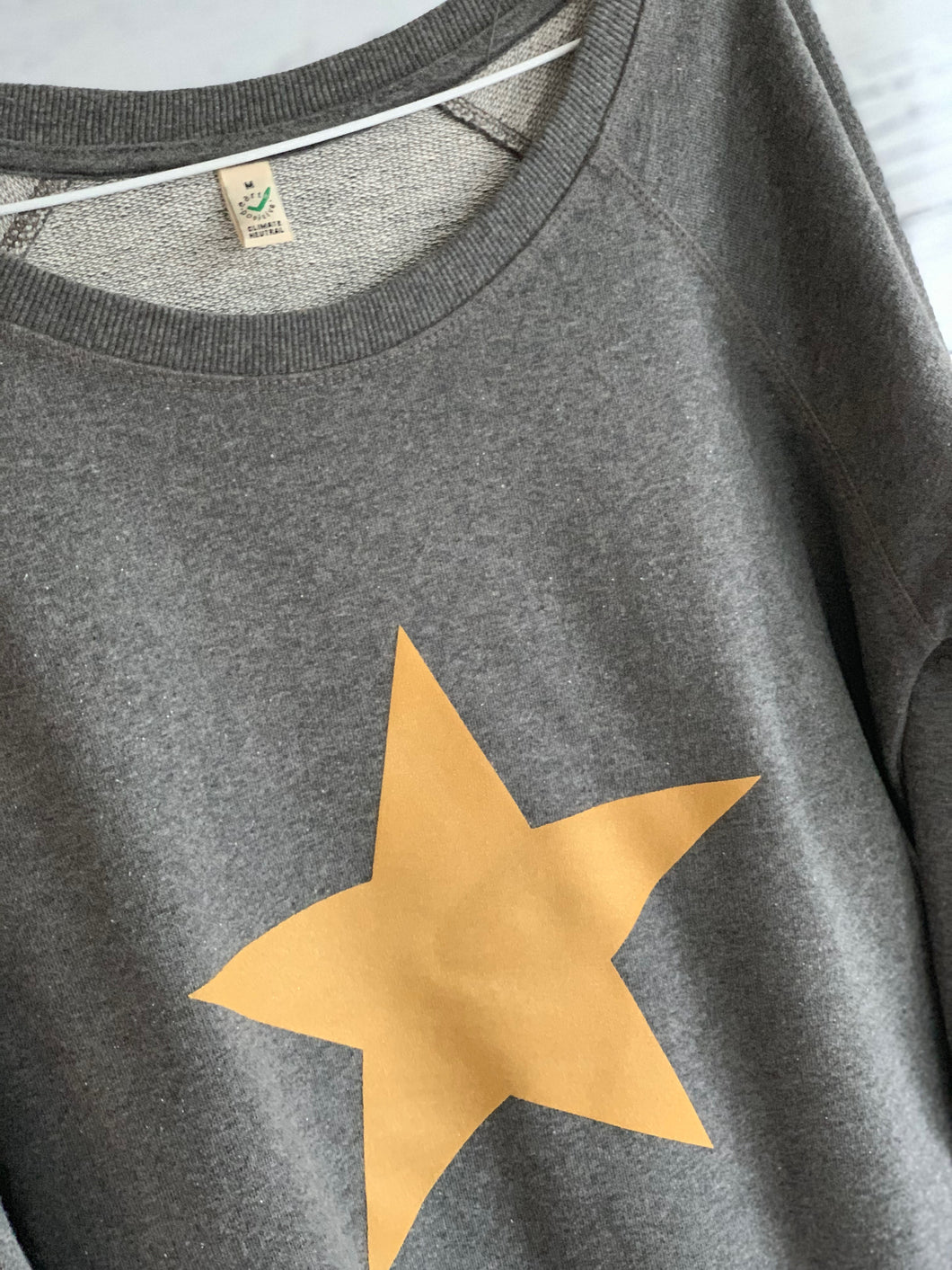 Gold star on dark grey sweatshirt (medium size 12)