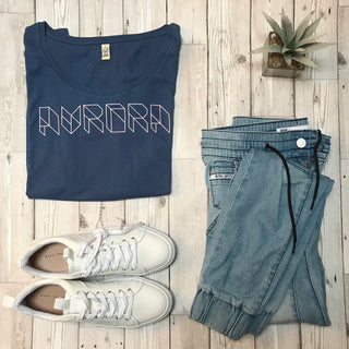 Pink geometric aurora font on denim blue tee